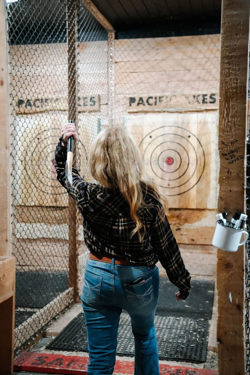 Guest throwing an axe at an indoor Pacific Axes lane